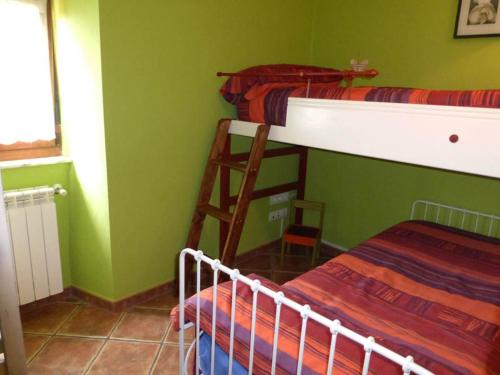 a bedroom with two bunk beds and a ladder at Apartamentos Rurales Los Galpones in Coaña