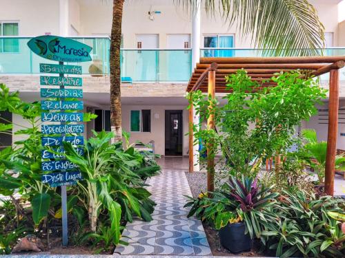 a street sign in front of a building with plants at Pousada Maresia Unique Beira Mar in Porto De Galinhas