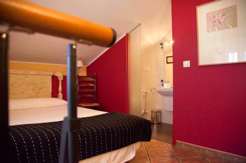 a red room with a bed and a sink at Apartamentos Rurales Los Galpones in Coaña