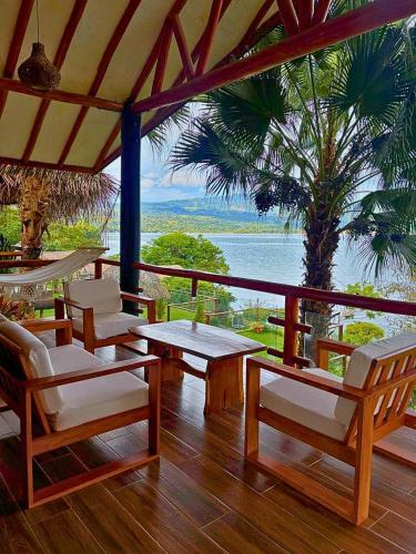 a porch with chairs and tables and a view of the ocean at Riosol Hotel Laguna Azul in Sauce