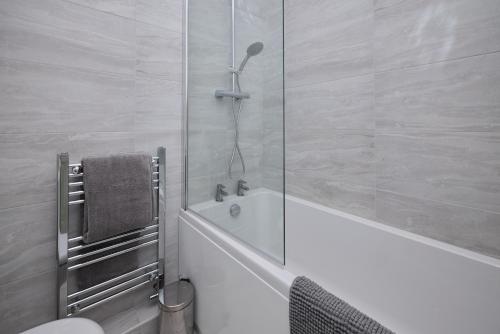 a bathroom with a shower with a tub and a toilet at The Corner by the Castle in Rochester