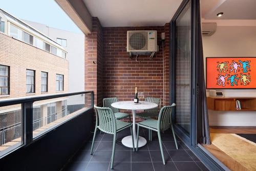 a balcony with a table and chairs on it at The Brass Flamingo on Oxford Street in Sydney