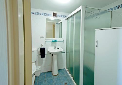 a bathroom with a toilet and a sink and a shower at Marcel Towers Holiday Apartments in Nambucca Heads