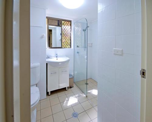 a white bathroom with a toilet and a sink at Marcel Towers Holiday Apartments in Nambucca Heads