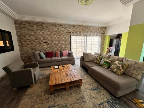 a living room with two couches and a coffee table at Goumland Diass in Diass