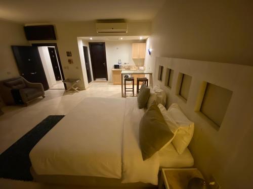 a bedroom with a large bed and a kitchen at Cozy studio in Azzurra Resort Sahl Hasheesh 65 Sq M in Hurghada