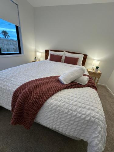 a bedroom with a large bed with two pillows at Family home, Game Zone & Outdoor Fireplace- Sleeps 10 in New Plymouth