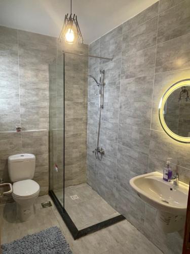 a bathroom with a shower and a toilet and a sink at Mountain view north coast in Banī Ghālib