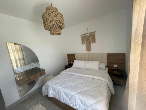 a bedroom with a bed and a mirror at Mountain view north coast in Banī Ghālib