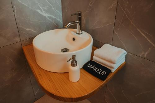 a bathroom sink on a wooden shelf with towels at Hotel Casa Acueducto - Lujo Cultural in Oaxaca City