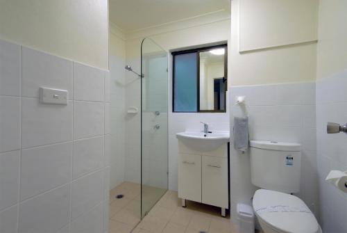 a bathroom with a toilet and a sink and a shower at Marcel Towers Holiday Apartments in Nambucca Heads