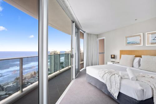 ゴールドコーストにあるH Residences - QStayの大きなベッドと大きな窓のある寝室