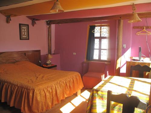 a bedroom with a bed and a chair and a window at Casa De Mama Cusco - The Treehouse in Cusco
