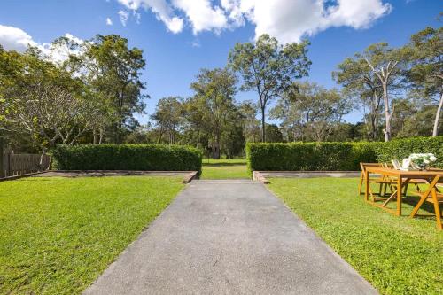 a pathway through a garden with a table and chairs at Stargaze&Soak Private Retreat Park-front Mins to Logan Hospital in Waterford