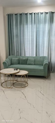 a living room with a green couch and a coffee table at AC Studio room at Sec 115, Kharar, Mohali in Mohali