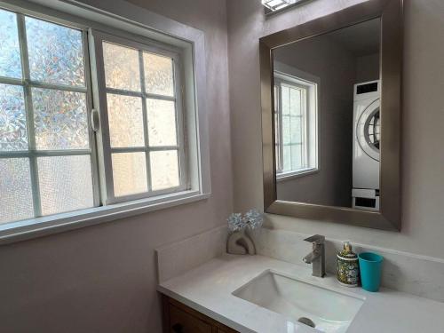 a bathroom with a sink and a mirror and windows at Fully Remodeled 2B1B Home in Baldwin3369 in Baldwin Park