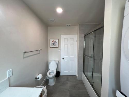 a bathroom with a toilet and a glass shower at Fully Remodeled 2B1B Home in Baldwin3369 in Baldwin Park