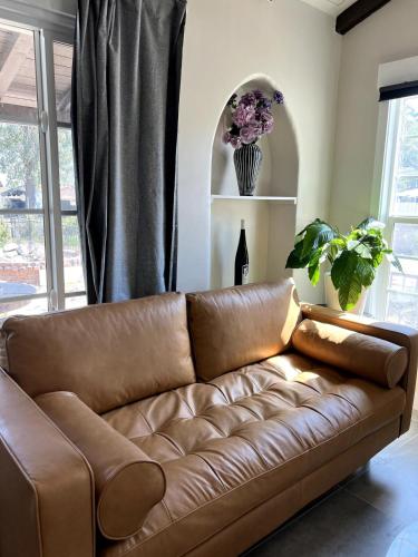 a brown leather couch in a living room with a window at Fully Remodeled 2B1B Home in Baldwin3369 in Baldwin Park