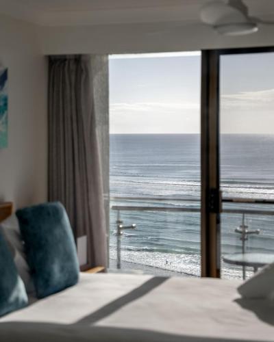 a bedroom with a view of the ocean from a window at Ocean Front Escape on Palm Beach in Gold Coast