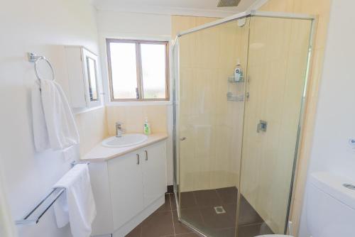 a bathroom with a shower and a sink at Belle's on Ballow - Kookaburra Lodge - Absolute Waterfront in Amity Point
