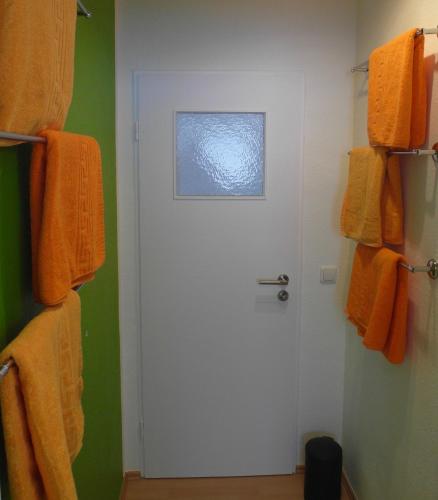 a bathroom with a white door and orange towels at Geschmackvolle Wohnung in Offenbach in Offenbach