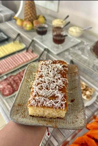 un trozo de pastel en un plato en un mostrador en Pousada Folhas de Outono, en Canela