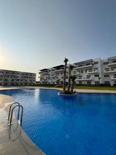 een groot zwembad voor een aantal appartementengebouwen bij Lux Rentals 2 chambres - CaboNegro in Cabo Negro