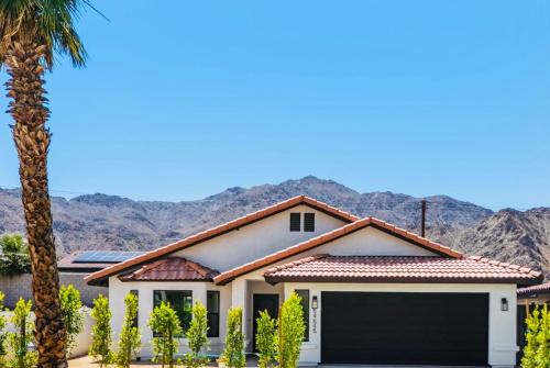 a house with a garage in front of mountains at La Quinta Cove Oasis - Pool,Spa,Hiking,Tennis,Golf,Stagecoach and Coachella! in La Quinta