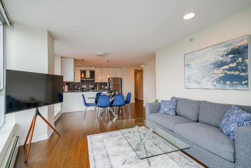 a living room with a couch and a kitchen at Gorgeous Unit with Beautiful City Views in Vancouver