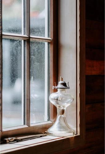 a glass bottle sitting on a window sill at Historical Hicks Cottage in Queenstown