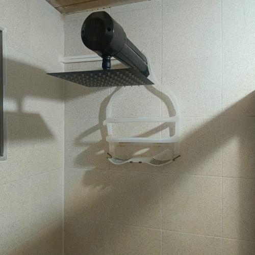 a hair dryer is on a shelf in a bathroom at DORMITORIOS - BAÑO y TV in Guarne