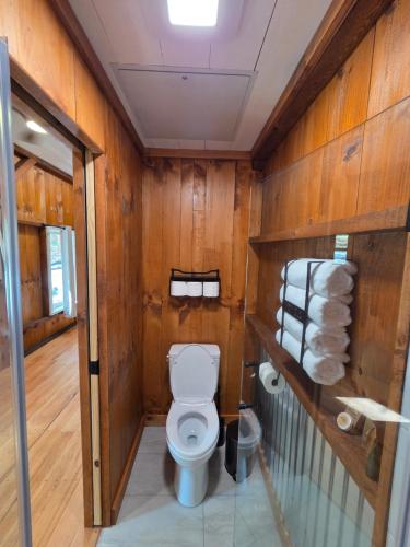 a bathroom with a toilet and some wooden walls at Lazy T Cabins - Glacier in Robbinsville