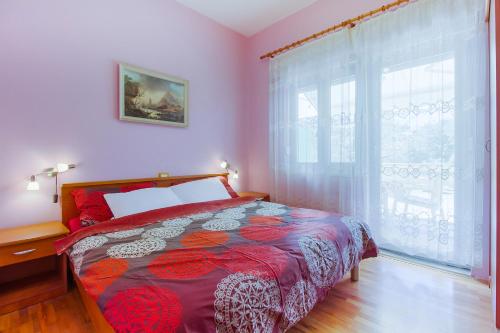 a bedroom with a bed and a large window at Apartment Oleander in Mali Lošinj