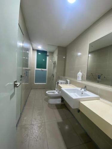 a bathroom with two sinks and a toilet and a mirror at Sutera Avenue near Gleaneagle KK King Bed in Kota Kinabalu