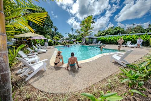 two people sitting around a pool at a resort at Mission Beach Hideaway Holiday Village in Mission Beach