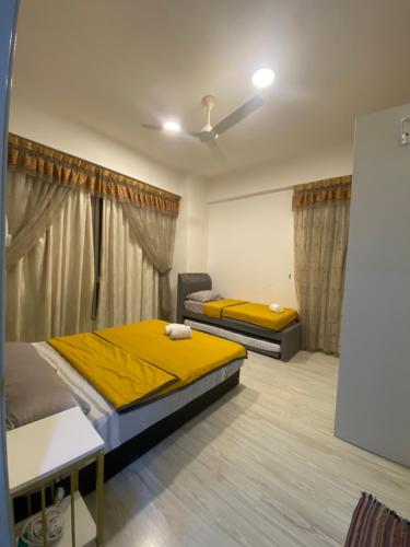 two beds in a room with yellow sheets at Sutera Avenue near Gleaneagle KK King Bed in Kota Kinabalu