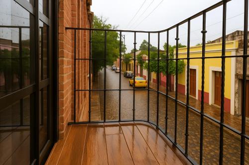 a balcony with a view of a street with a yellow car at Hotel Casa Acueducto - Lujo Cultural in Oaxaca City