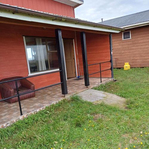 a front porch of a house with a fence at CABAÑAS MAR BRAVA in Ancud