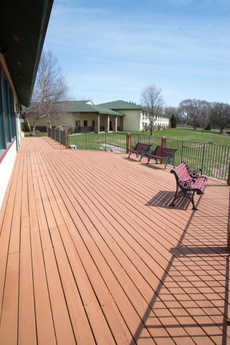 two benches sitting on a wooden deck at HomeTown Inn and Suites Belle Plaine in Belle Plaine