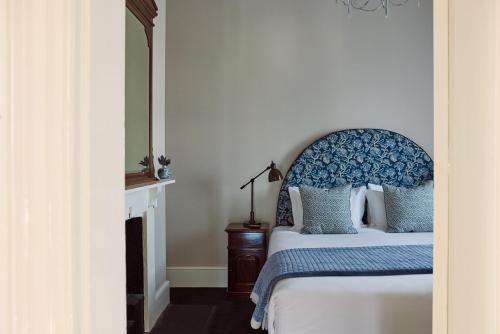 a bedroom with a bed with a blue headboard at The Customs House Port MacDonnell in Port MacDonnell