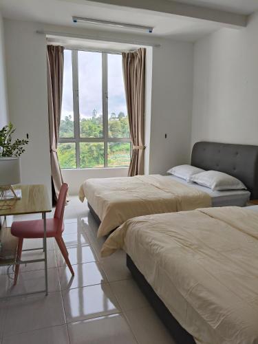 a bedroom with two beds and a desk and a window at KhaiLa Emerald Apartment Cameron Highlands in Brinchang