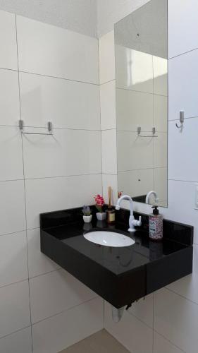 a bathroom with a sink and a mirror at Nalevaiko - Kitnet Moderna e Funcional in Sinop