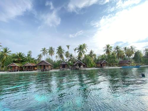 a view of a beach with huts on the water at Fam Homestay in Fam