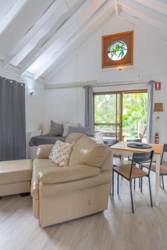 a living room with a couch and a table at Belles on Ballow - Lorikeet Lodge - Absolute Waterfront in Amity Point