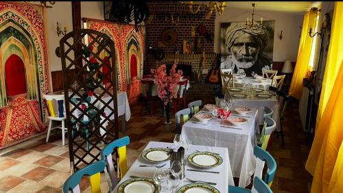 a dining room with white tables and chairs and a painting at le chalet de Lola in Saint-Michel