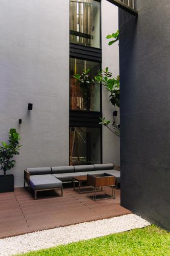 a building with benches and tables in front of it at AMANOR Hotel Chiang Mai in Chiang Mai