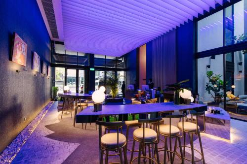 a restaurant with blue tables and stools at AMANOR Hotel Chiang Mai in Chiang Mai