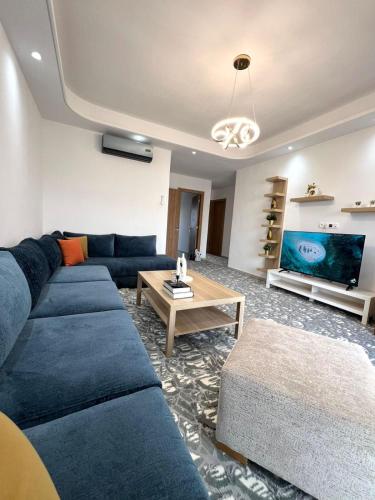 a living room with a blue couch and a table at Appartement Moderne à CABO Huerto Del Rio in Cabo Negro