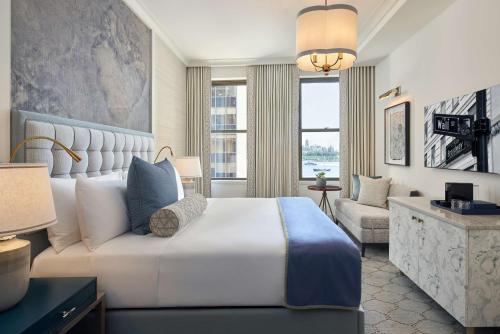 a bedroom with a large bed and a living room at The Wall Street Hotel by Suiteness in New York