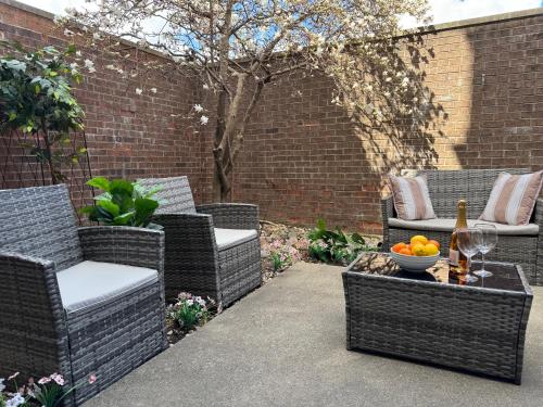 a patio with wicker chairs and a table with a bottle of wine at 4 Bedroom Home in Best Location Parking Fireplace Back Yard Pets Welcome in Chicago